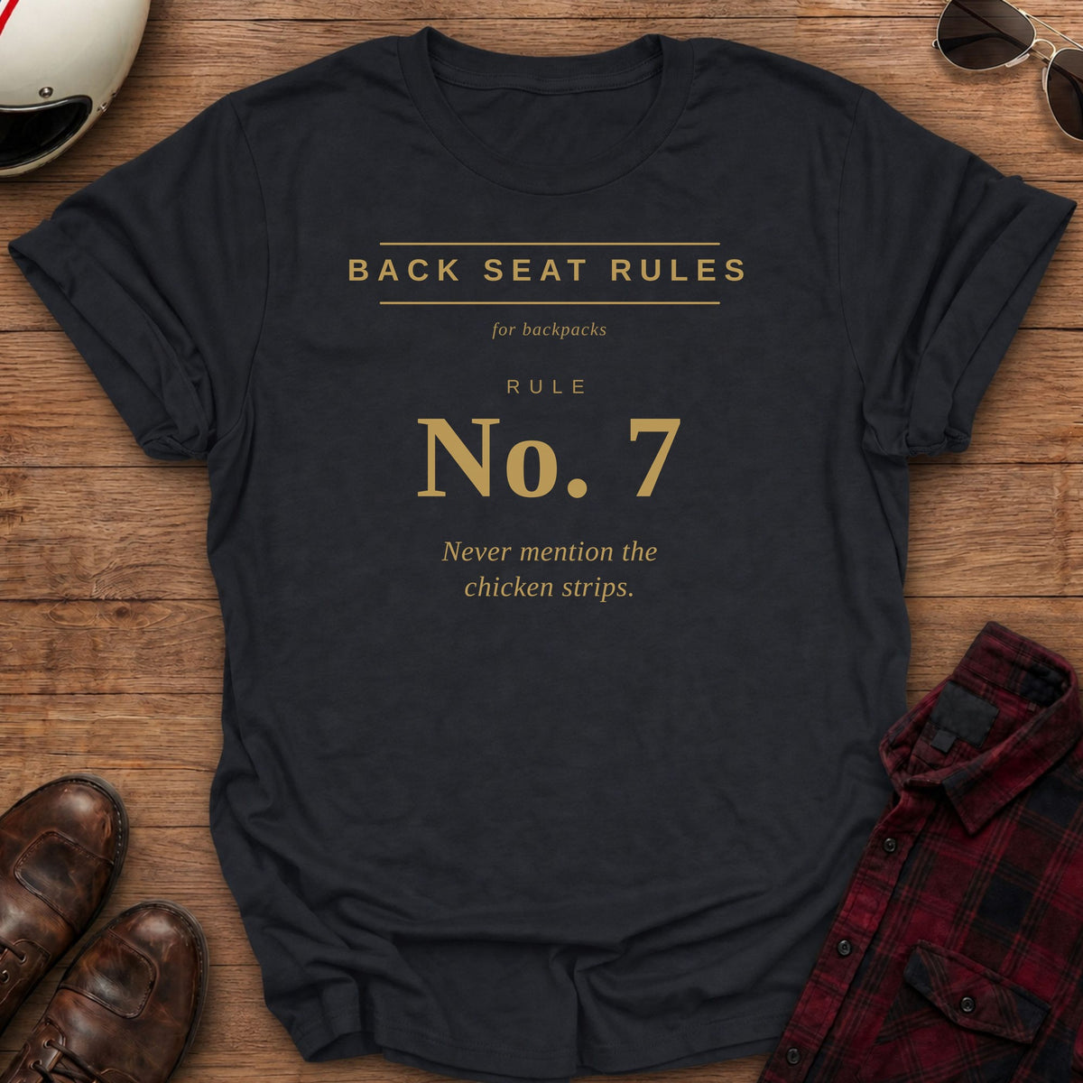 Black t-shirt with gold type on the front reading Back Seat Rules, for backpacks, Rule No. 7: Never mention the chicken strips.