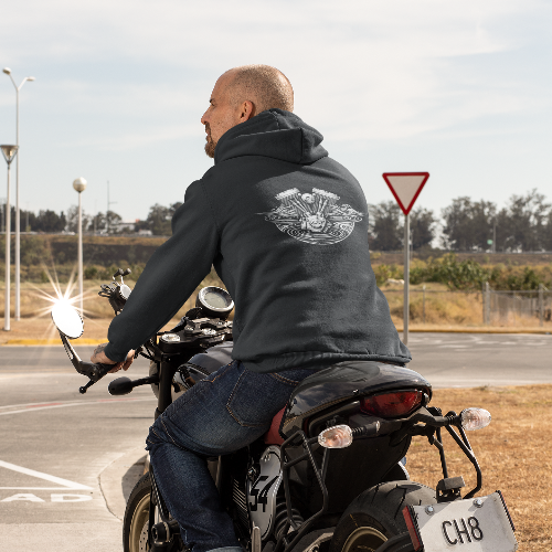Man riding a motorcycle on a road with a clear sky