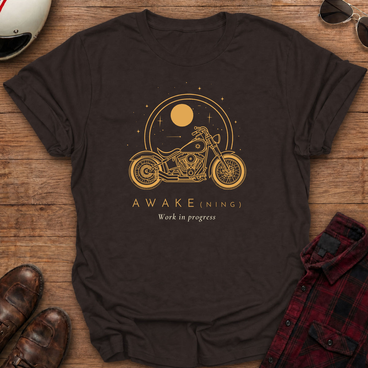 Dark chocolate t-shirt with gold line art of a cruiser motorcycle under a large sun inside a double ring with stars, text reads AWAKE(NING), Work in progress