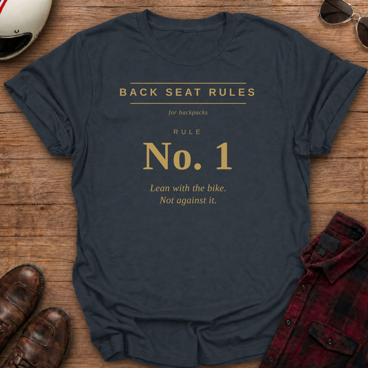 Heather Navy t-shirt with gold type on the front reading Back Seat Rules, for backpacks, Rule No. 1: Lean with the bike. Not against it.