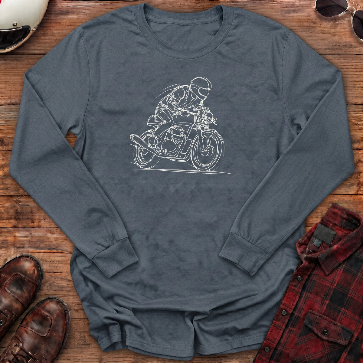 Dark heather grey long-sleeve shirt with a loose white line-art sketch of a helmeted rider tucked low on a cafe racer motorcycle leaning into a corner, with wind lines and a ground line