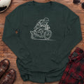 Forest green long-sleeve shirt with a loose white line-art sketch of a helmeted rider tucked low on a cafe racer motorcycle leaning into a corner, with wind lines and a ground line