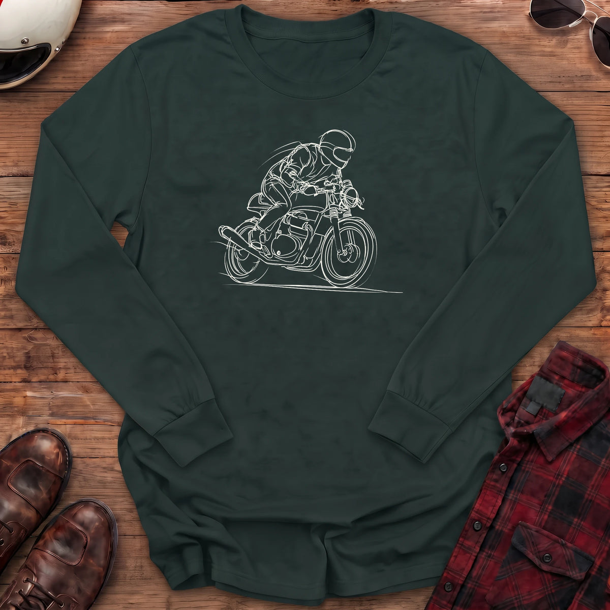 Forest green long-sleeve shirt with a loose white line-art sketch of a helmeted rider tucked low on a cafe racer motorcycle leaning into a corner, with wind lines and a ground line